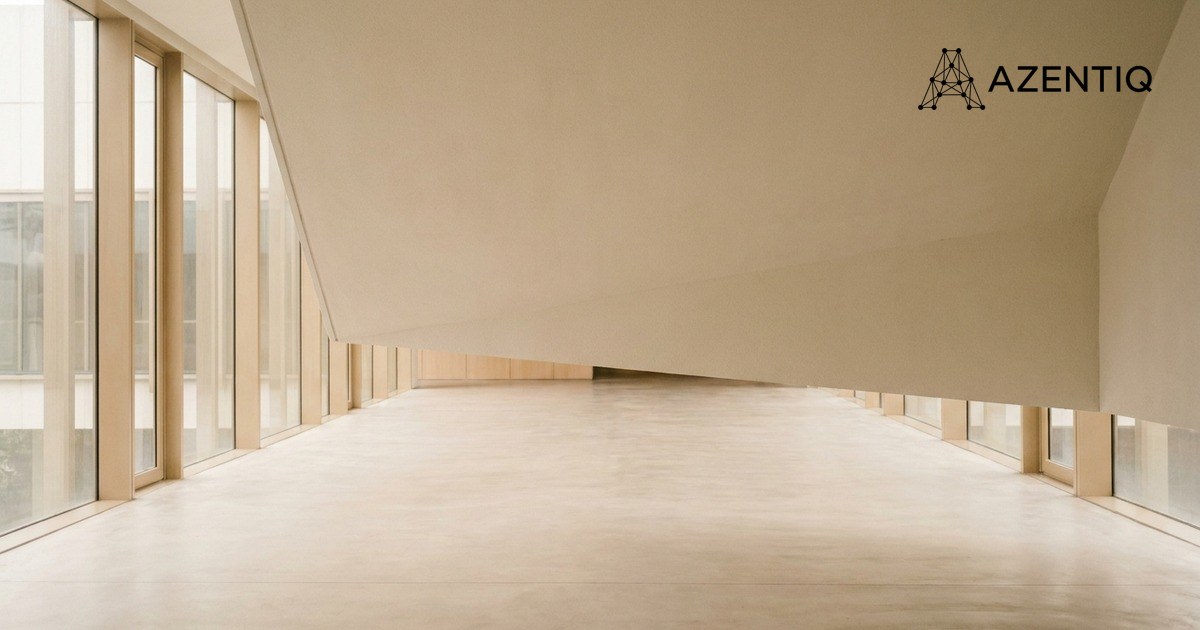 An empty enclosed walkway between two office buildings, glazed on both sides, with a pale floor running away from the camera
