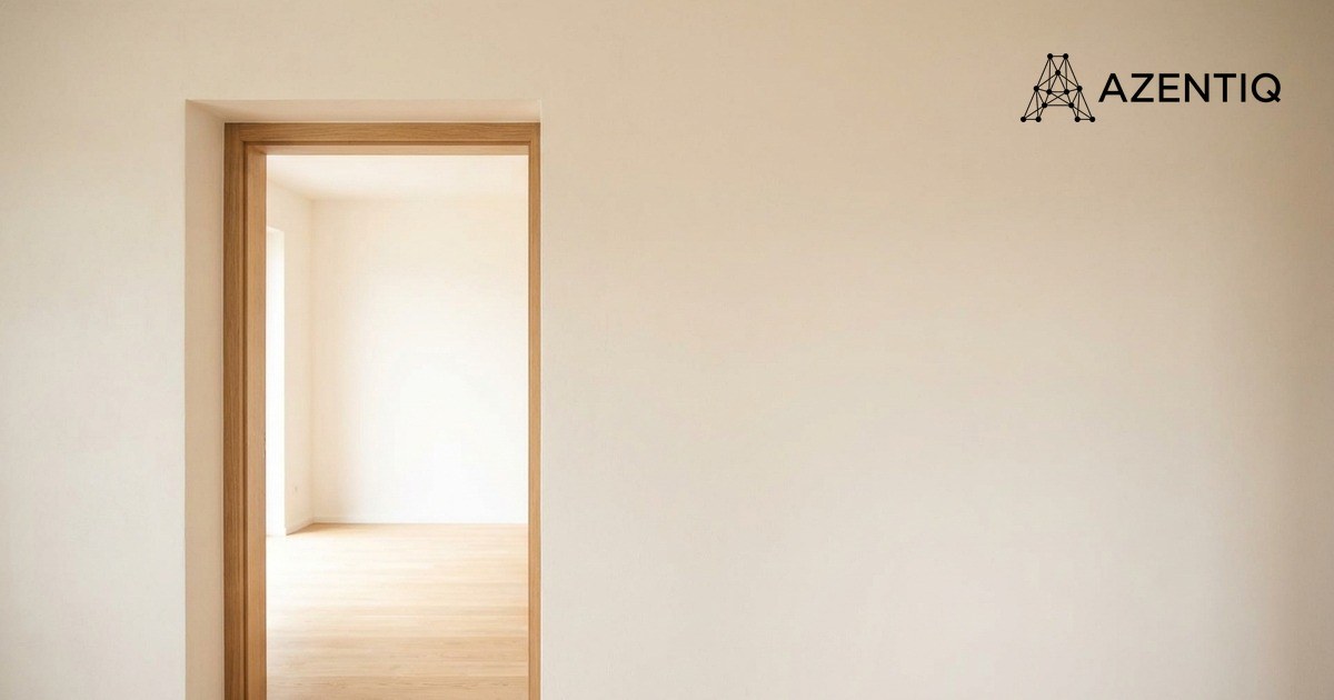 An open doorway in a plain pale wall looking through into a bright empty room